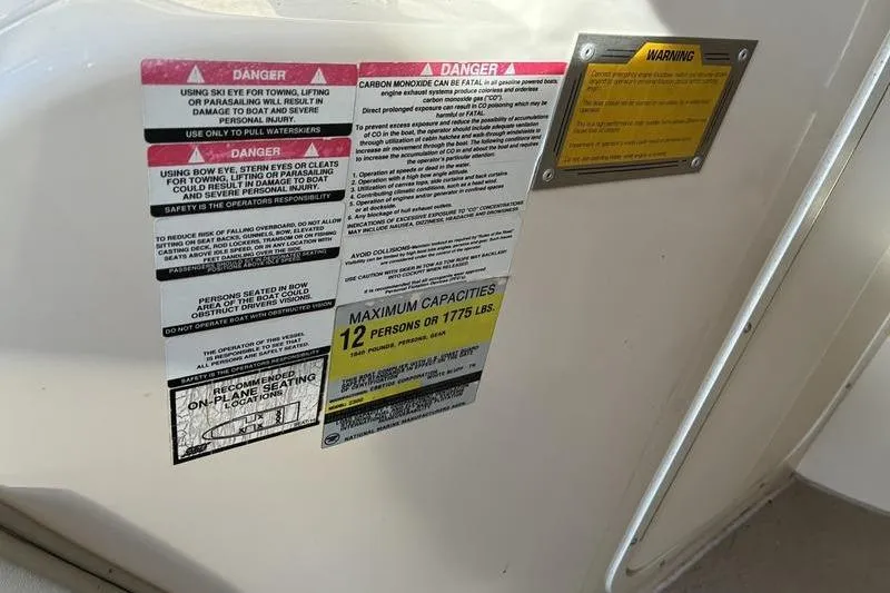 Slide: The Image of 1999 Ebbtide 2300 boat warning labels, maximum capacity 12 persons or 1775 lbs. - 21