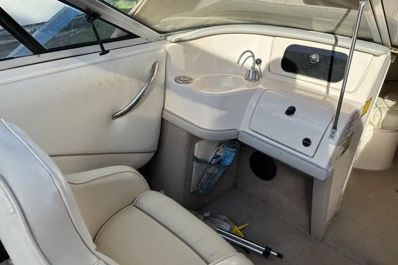Slide: The Image of Interior of a 1999 Ebbtide 2300 boat featuring a sink and seating area. - 24