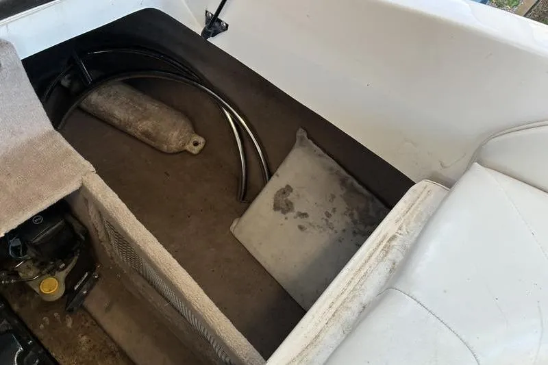 Slide: The Image of Interior of a 1999 Ebbtide 2300 boat showing storage compartment and seating. - 36