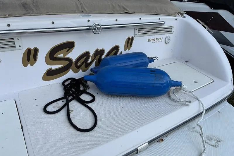 Slide: The Image of 1999 Ebbtide 2300 boat stern with blue fenders and "Sara" nameplate. - 43