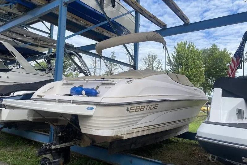 Slide: The Image of 1999 Ebbtide 2300 boat on storage rack, surrounded by trees and other boats. - 5