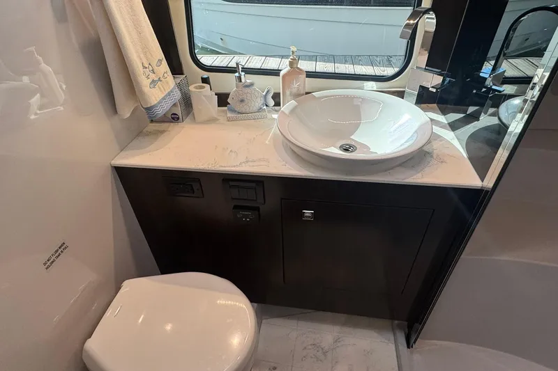 Slide: The Image of Luxurious bathroom in 2022 Cruisers Yachts 390 Express Coupe with modern sink and elegant fixtures. - 10