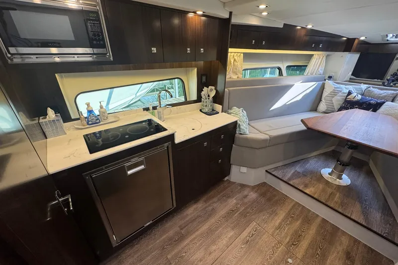 Slide: The Image of Luxurious interior of 2022 Cruisers Yachts 390 Express Coupe with modern kitchen and seating area. - 12