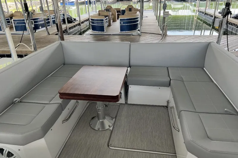 Slide: The Image of 2022 Cruisers Yachts 390 Express Coupe interior with gray seating and wooden table. - 4