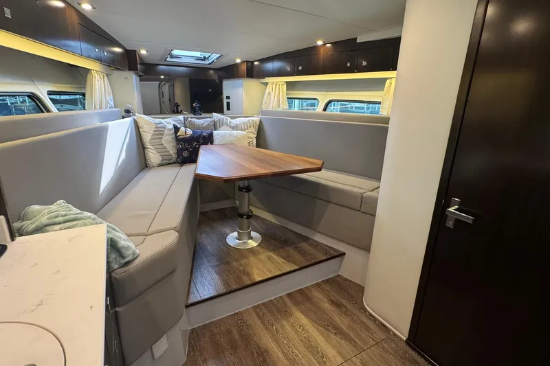 Slide: The Image of 2022 Cruisers Yachts 390 Express Coupe interior with modern seating and wooden table. - 7
