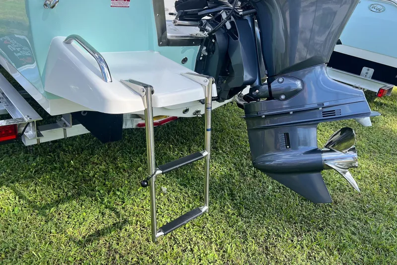 Slide: The Image of 2026 Key West 1720 Center Console boat with motor and swim ladder on grass. - 5