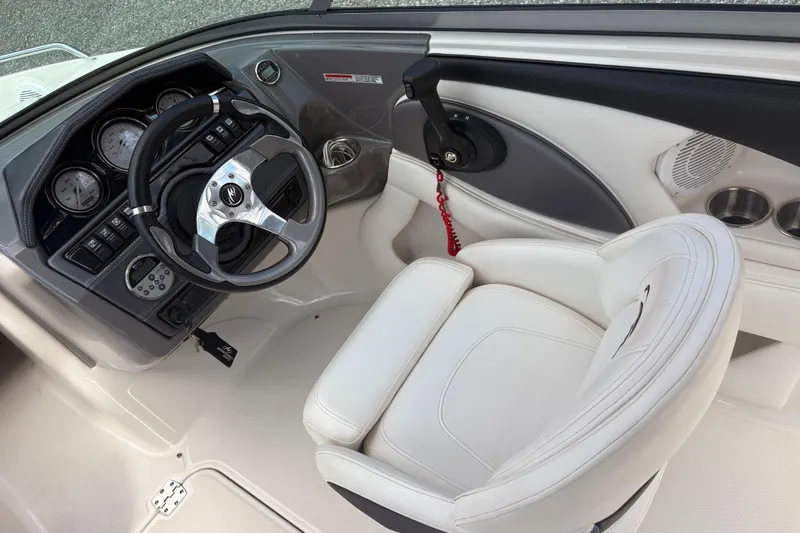 Slide: The Image of 2011 Monterey 204FS boat cockpit with steering wheel and white captain's chair. - 18