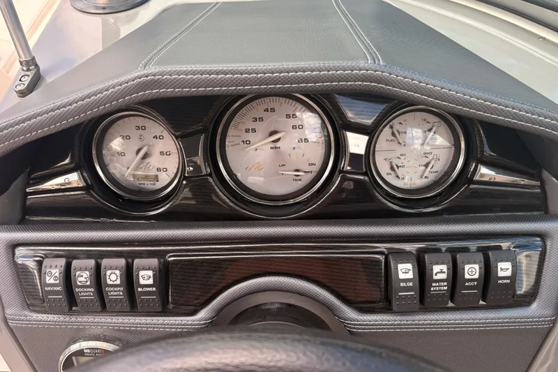 Slide: The Image of Dashboard of a 2011 Monterey 204FS boat with gauges and control switches. - 19