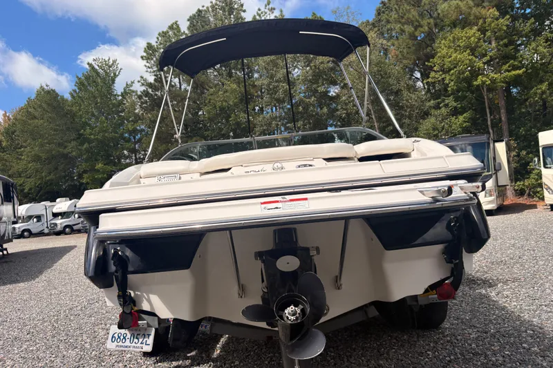 Slide: The Image of 2011 Monterey 204FS boat with canopy, parked on gravel, surrounded by trees and RVs. - 25