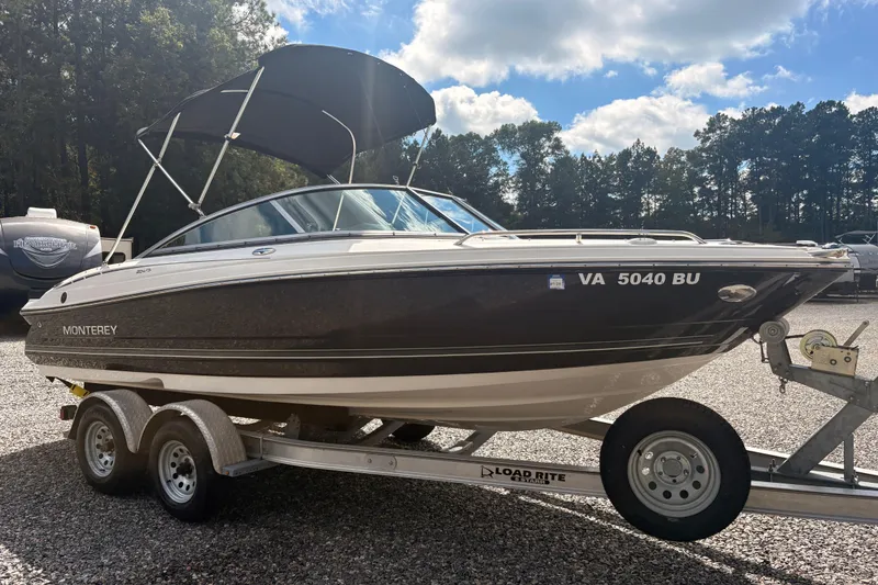 Slide: The Image of 2011 Monterey 204FS boat on trailer, parked outdoors under a sunny sky. - 27