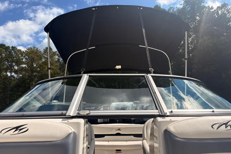 Slide: The Image of 2011 Monterey 204FS boat with canopy, viewed from the rear, under a clear sky. - 34
