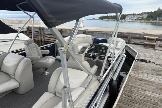 Slide: The Image of 2015 Sylvan Mirage Cruise 8522 LZ pontoon boat docked by a serene waterfront. - 7