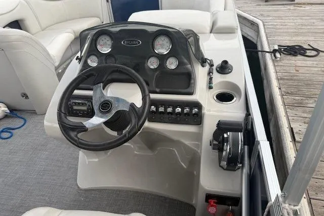 Slide: The Image of 2015 Sylvan Mirage Cruise 8522 LZ boat dashboard with steering wheel and gauges. - 8
