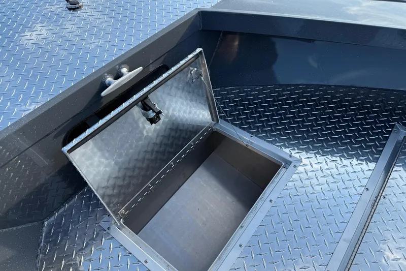 Slide: The Image of Open storage compartment on 2026 Fish Rite River Master 18 boat with diamond plate flooring. - 22