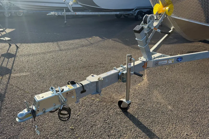 Slide: The Image of Trailer hitch of 2026 Fish Rite River Master 18 boat on asphalt surface. - 23