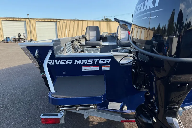 Slide: The Image of 2026 Fish Rite River Master 18 boat with Suzuki engine, parked outdoors. - 7