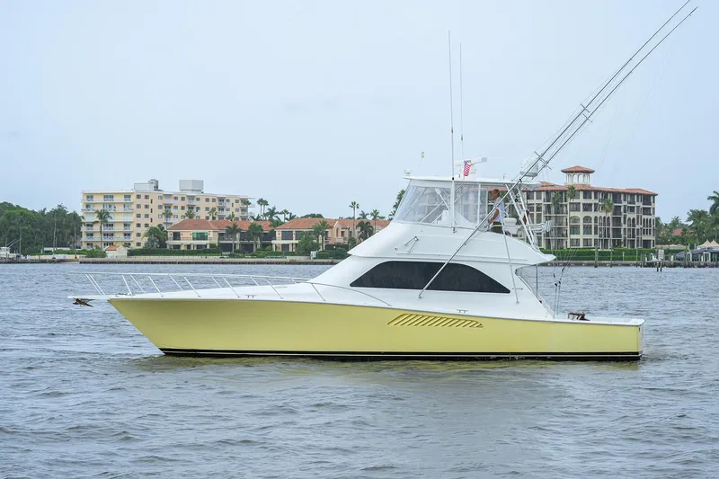The Image of 2004 Viking 48 Convertible yacht on water with coastal buildings in background. - 0
