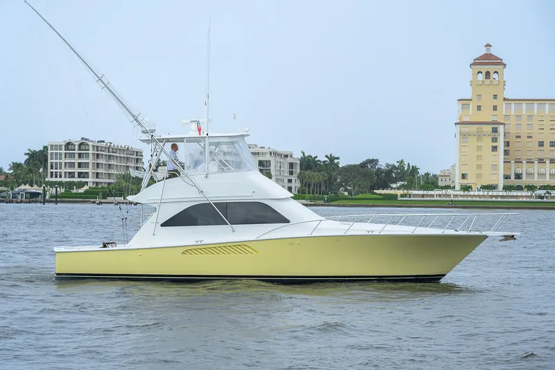 Slide: The Image of 2004 Viking 48 Convertible yacht cruising near waterfront buildings. - 10