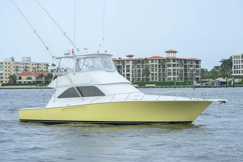 Slide: The Image of 2004 Viking 48 Convertible yacht cruising near waterfront buildings. - 12