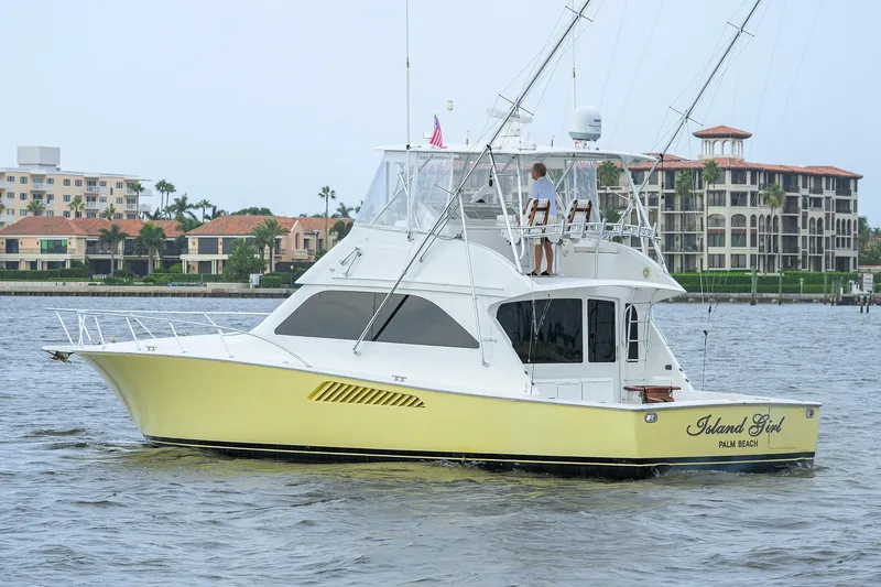 Slide: The Image of 2004 Viking 48 Convertible yacht, "Island Girl," cruising near waterfront buildings. - 2