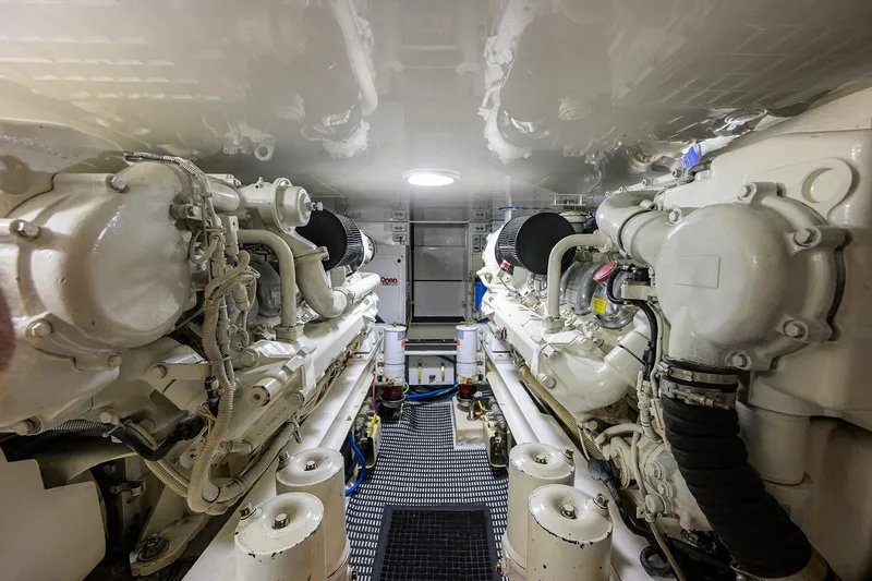 Slide: The Image of Engine room of a 2004 Viking 48 Convertible yacht, showcasing dual engines and mechanical components. - 23