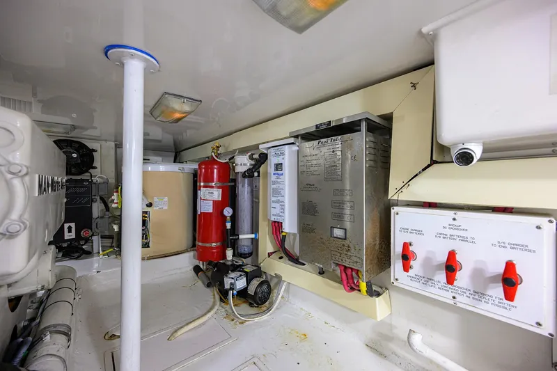 Slide: The Image of Engine room of 2004 Viking 48 Convertible yacht with electrical panels and fire extinguisher. - 25