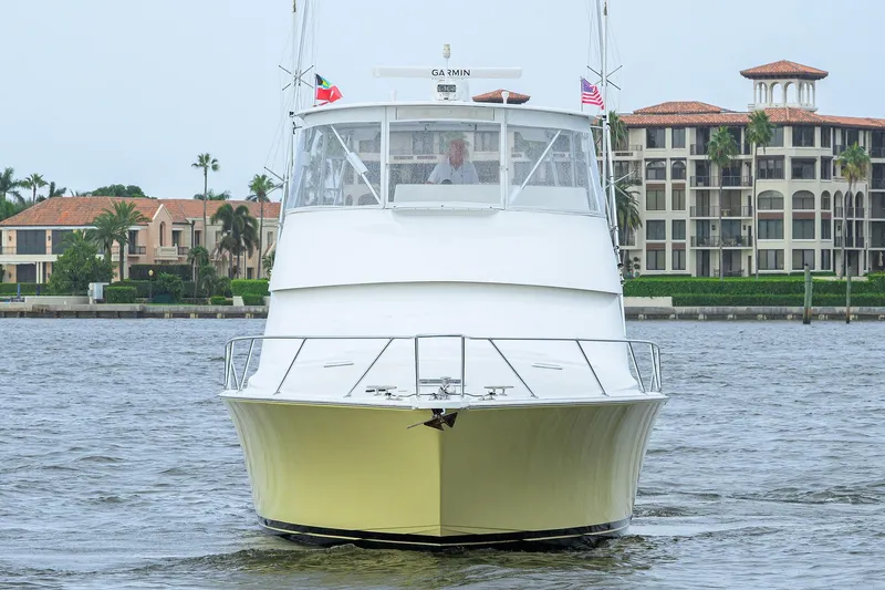 Slide: The Image of 2004 Viking 48 Convertible yacht on water, with luxury buildings in the background. - 3