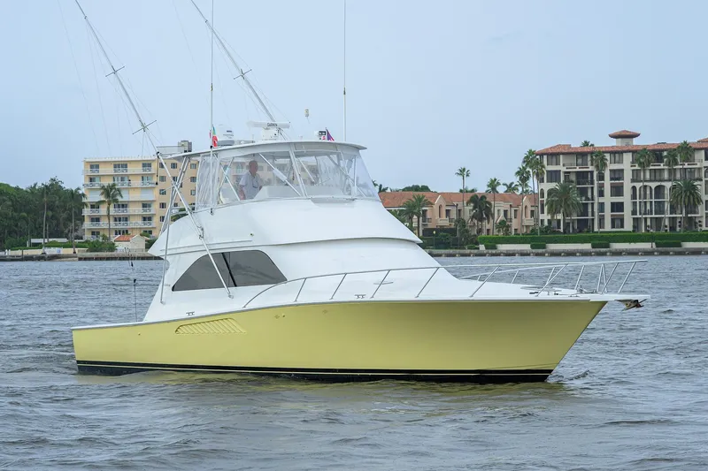 Slide: The Image of 2004 Viking 48 Convertible yacht cruising near waterfront buildings. - 4