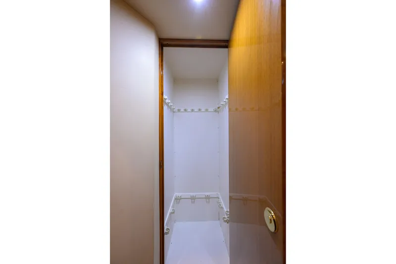Slide: The Image of Interior view of a 2004 Viking 48 Convertible yacht's storage closet with wooden door. - 46