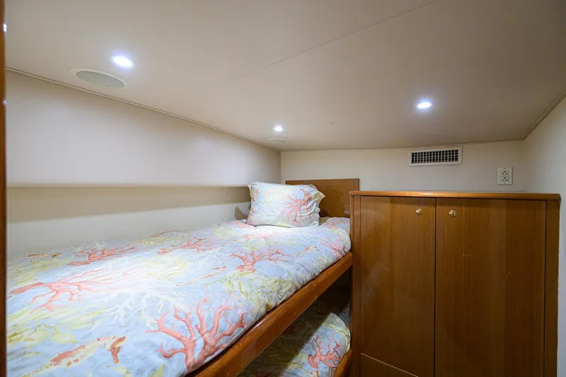 Slide: The Image of Cozy cabin interior of 2004 Viking 48 Convertible yacht with single bed and wooden cabinetry. - 49