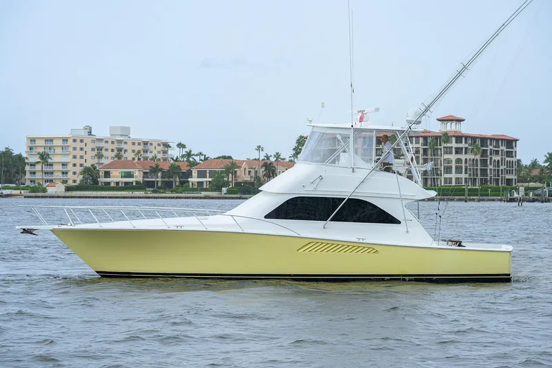 Slide: The Image of 2004 Viking 48 Convertible yacht cruising near waterfront buildings. - 5
