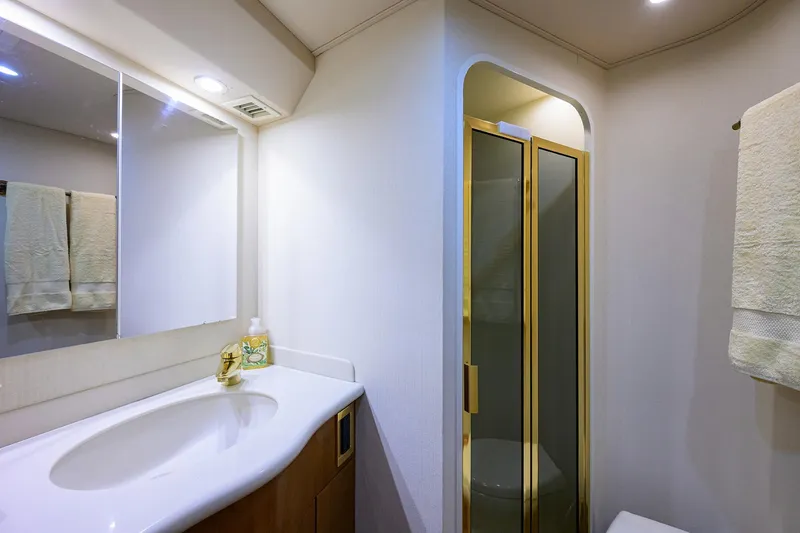 Slide: The Image of Luxurious bathroom in 2004 Viking 48 Convertible yacht with modern fixtures and gold-accented shower. - 50