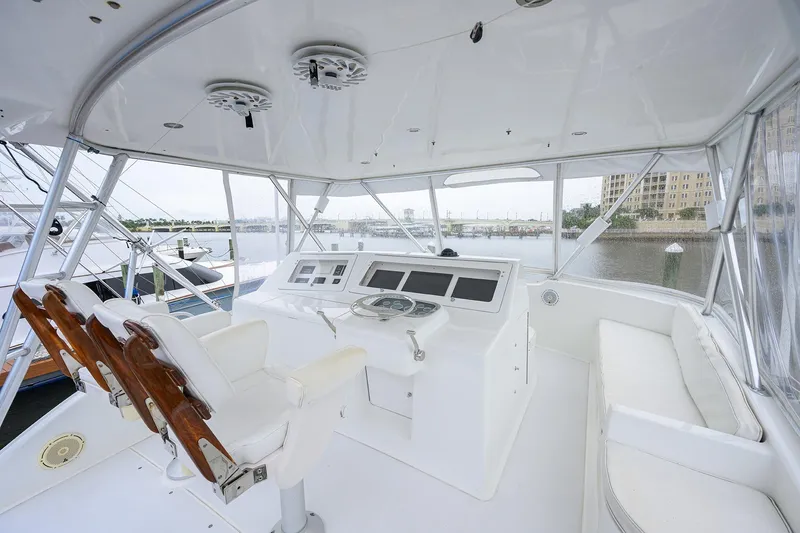Slide: The Image of Interior view of 2004 Viking 48 Convertible yacht helm with white seating and controls. - 56