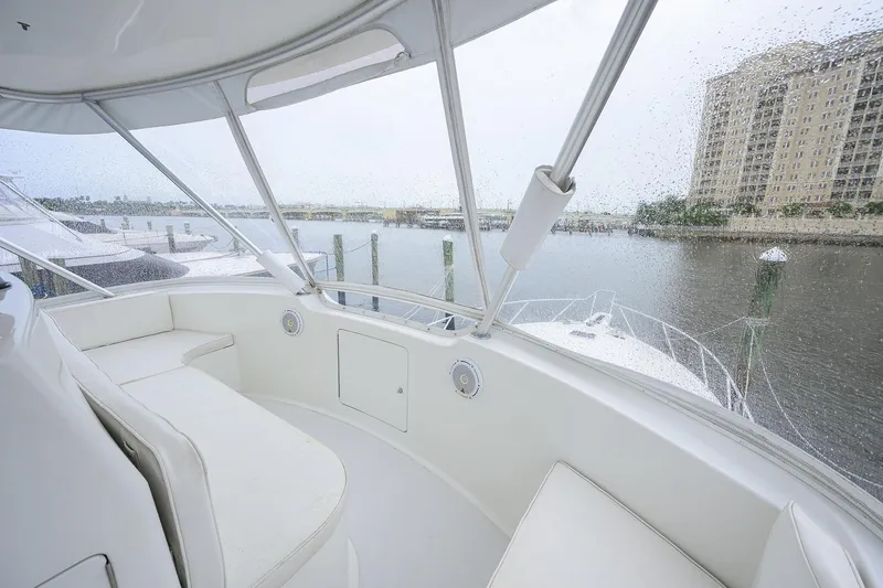 Slide: The Image of 2004 Viking 48 Convertible yacht interior with waterfront view through rain-speckled windows. - 57