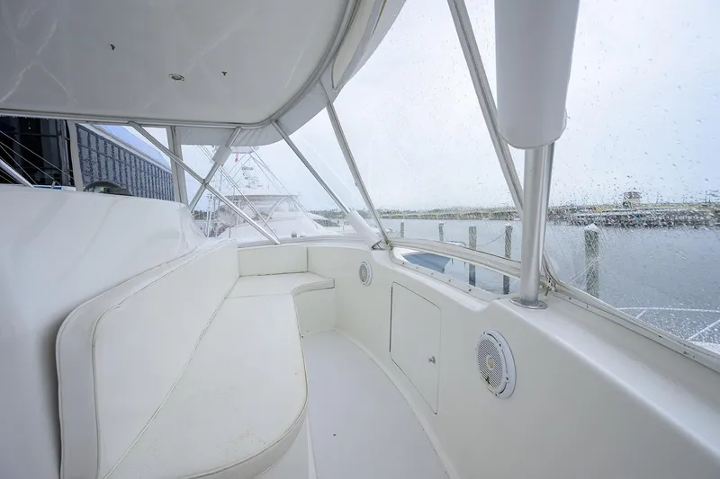 Slide: The Image of 2004 Viking 48 Convertible yacht interior with white seating and marina view. - 61