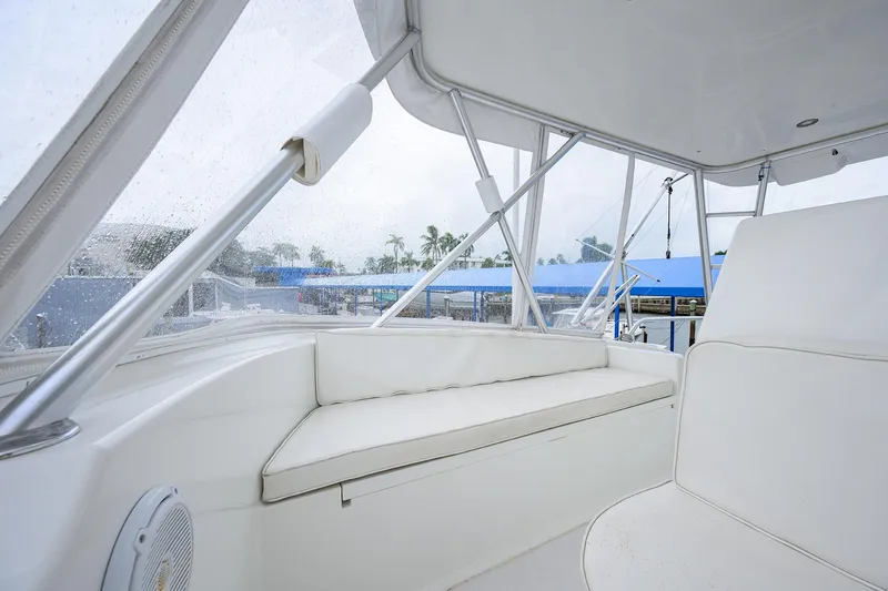 Slide: The Image of 2004 Viking 48 Convertible yacht interior with white seating and clear windows. - 62