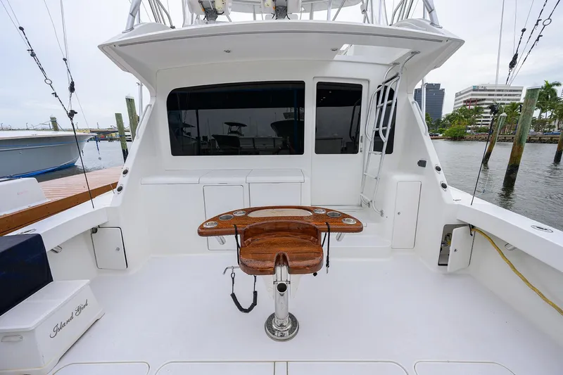 Slide: The Image of 2004 Viking 48 Convertible yacht cockpit with fishing chair and waterfront view. - 66