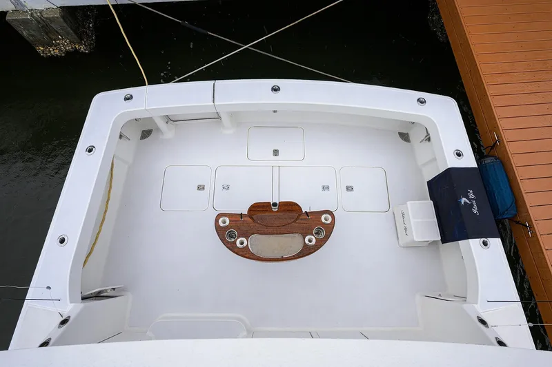 Slide: The Image of 2004 Viking 48 Convertible yacht deck with fishing setup and storage compartments. - 71