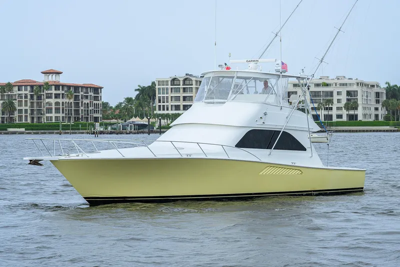 Slide: The Image of 2004 Viking 48 Convertible yacht cruising near waterfront buildings. - 9