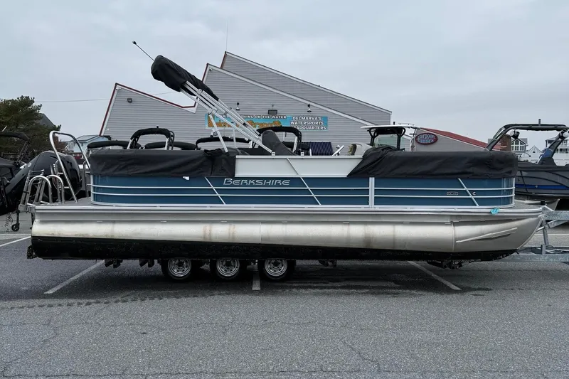 The Image of 2025 Berkshire 24RFX LE 2.75 pontoon boat parked on a trailer in a lot. - 11