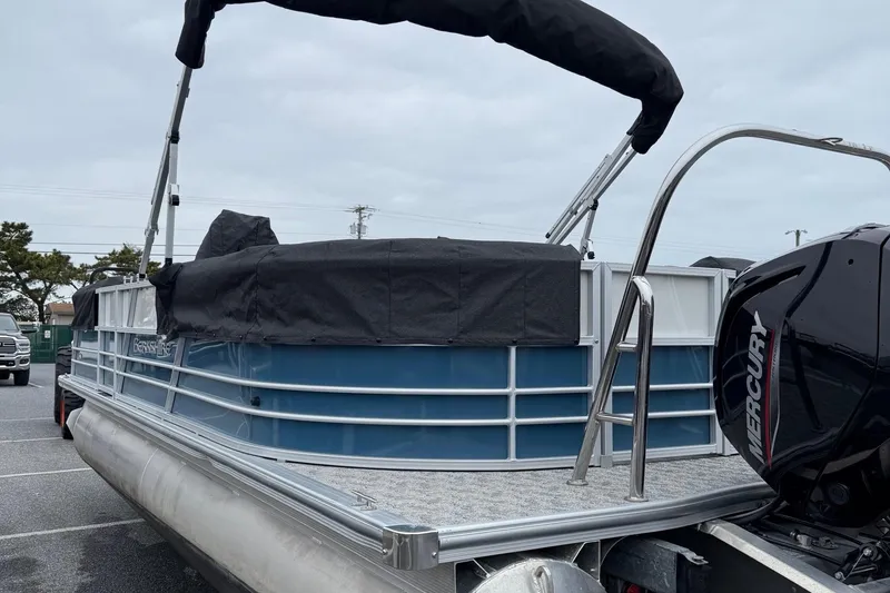 Slide: The Image of 2025 Berkshire 24RFX LE 2.75 pontoon boat with Mercury engine, parked outdoors. - 16