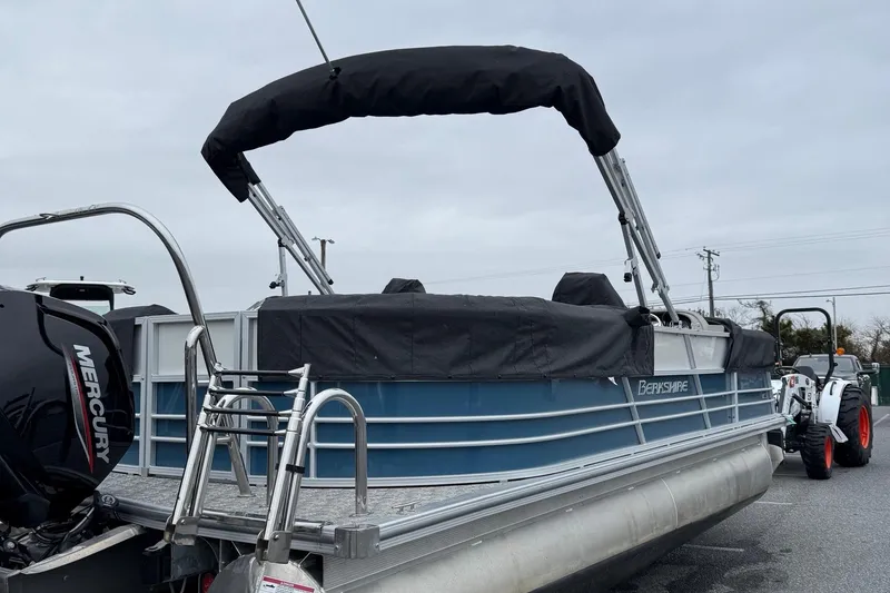 Slide: The Image of 2025 Berkshire 24RFX LE 2.75 pontoon boat with Mercury engine, parked outdoors. - 18