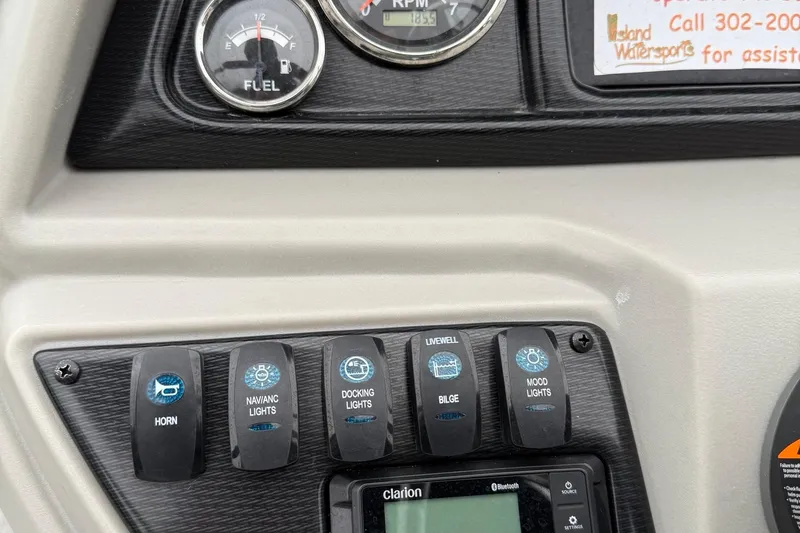 Slide: The Image of Control panel of 2025 Berkshire 24RFX LE 2.75 boat with switches and gauges. - 24