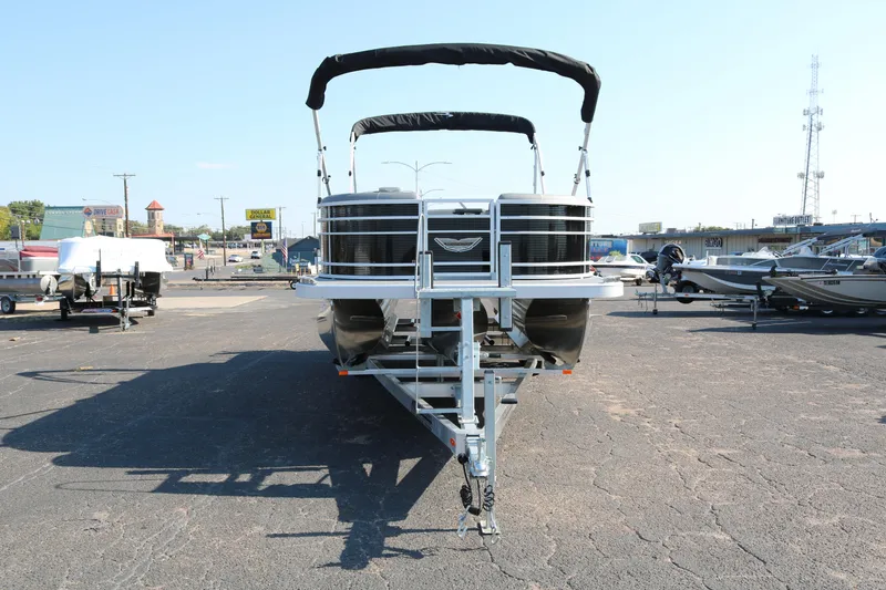 Slide: The Image of 2025 Bennington 22 LSWING BACK pontoon boat on trailer in parking lot. - 2