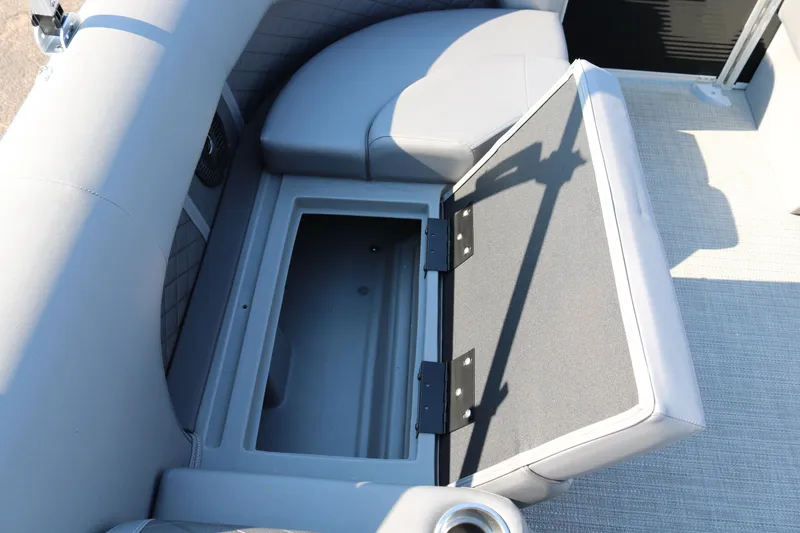Slide: The Image of 2025 Bennington 22 LSWING BACK boat with open storage compartment and cushioned seating. - 24