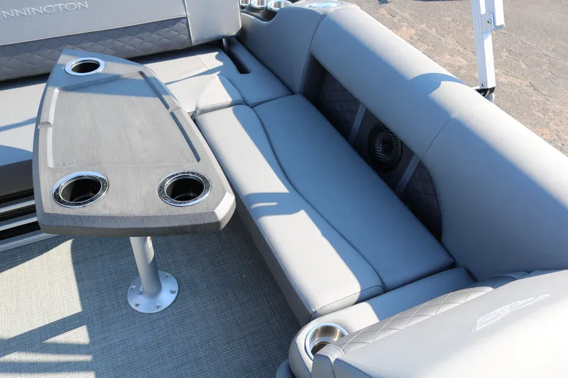 Slide: The Image of 2025 Bennington 22 LSWING BACK boat interior with gray seating and table with cup holders. - 26
