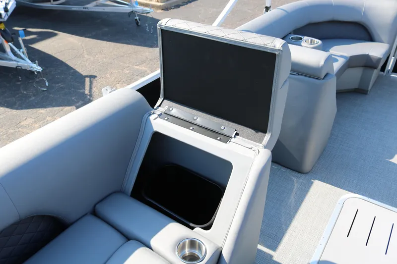 Slide: The Image of 2025 Bennington 22 LSWING BACK boat interior with open storage compartment and cup holders. - 29
