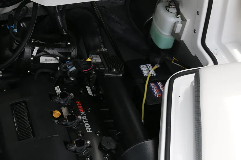 Slide: The Image of Engine compartment of 2026 Scarab 215 SE, featuring Rotax engine components and battery. - 21