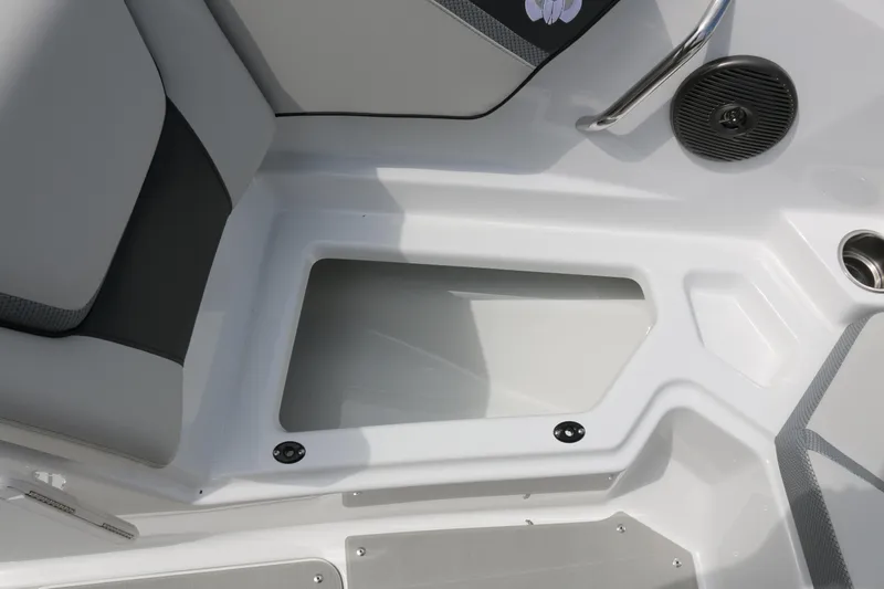 Slide: The Image of 2026 Scarab 215 SE boat interior storage compartment with gray seating and speaker. - 8