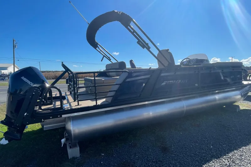 Slide: The Image of 2026 Starcraft SLS 3 Q DH pontoon boat on gravel lot under blue sky. - 6